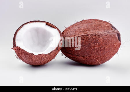 Tutta crepata e noci di cocco su sfondo chiaro. Foto Stock