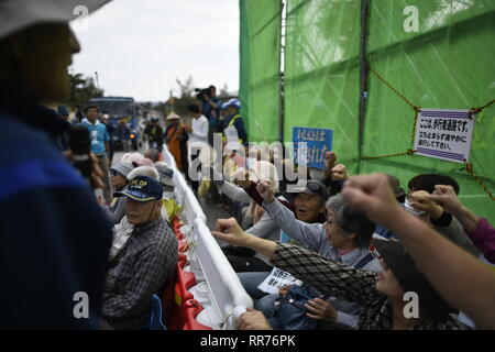 NAGO, Giappone - 25 febbraio: manifestanti con cartelli bloccare i veicoli per la costruzione di entrare nel cantiere durante anti base usa protesta al di fuori di Stati Uniti Base Camp Schwab gate in febbraio 25, 2019 di Nago, Prefettura di Okinawa, in Giappone. Anti-base U.S manifestanti stadio un sit-in di protesta contro il cancello di U.S. Marine Corps' Camp Schwab bloccando il passaggio di veicoli da cantiere mobilitate dal governo giapponese per rallentare il trasferimento nella nuova U.S Airbase stazione in Henoko. Credito: Richard Atrero de Guzman/ AFLO/Alamy Live News Foto Stock