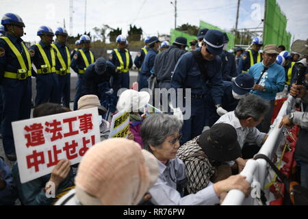 NAGO, Giappone - 25 febbraio: manifestanti con cartelli bloccare i veicoli per la costruzione di entrare nel cantiere durante anti base usa protesta al di fuori di Stati Uniti Base Camp Schwab gate in febbraio 25, 2019 di Nago, Prefettura di Okinawa, in Giappone. Anti-base U.S manifestanti stadio un sit-in di protesta contro il cancello di U.S. Marine Corps' Camp Schwab bloccando il passaggio di veicoli da cantiere mobilitate dal governo giapponese per rallentare il trasferimento nella nuova U.S Airbase stazione in Henoko. (Foto di Richard Atrero de Guzman/ Aflo) Foto Stock