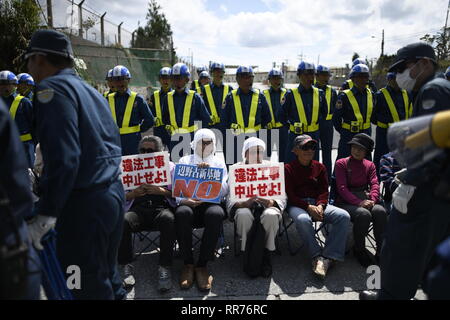 NAGO, Giappone - 25 febbraio: manifestanti con cartelli bloccare i veicoli per la costruzione di entrare nel cantiere durante anti base usa protesta al di fuori di Stati Uniti Base Camp Schwab gate in febbraio 25, 2019 di Nago, Prefettura di Okinawa, in Giappone. Sulla base del referendum prefettizio risultato, oltre il 70 percento degli elettori in Okinawa respingere Usa Trasferimento base a Henoko. (Foto di Richard Atrero de Guzman/ Aflo) Foto Stock