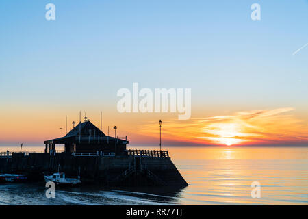 Sunrise, sunup, oltre il mare della Manica, a Viking Bay e il porto, Broadstairs. Sottile fascia di cloud e il cielo arancione sull'orizzonte con il cielo azzurro sopra. Foto Stock