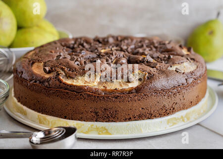 Cioccolato artigianale torta di pere. Tutta la torta da vicino. Pere mature in background. Foto Stock