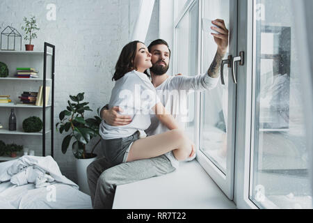 Bella coppia Giovane tenendo selfie sullo smartphone a casa Foto Stock