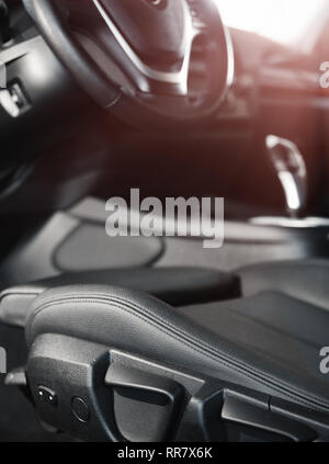 Dark auto di lusso interni.il volante, la leva del cambio e il cruscotto. Per interni auto di lusso. I pannelli di colore nero. Foto Stock