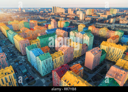 Vista aerea dei colorati edifici in città europea al tramonto. Paesaggio con case variopinte, auto sulla strada a Kiev in Ucraina. Vista dall'alto. U Foto Stock