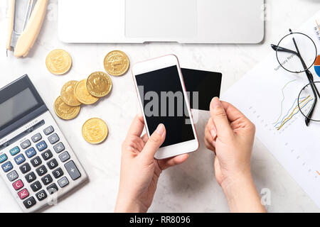 Una donna sta facendo un pagamento online con carta di smartphone e isolate su un moderno ufficio in marmo tavolo, mock up, vista dall'alto, copia spazio, piana, laici lifestyl Foto Stock