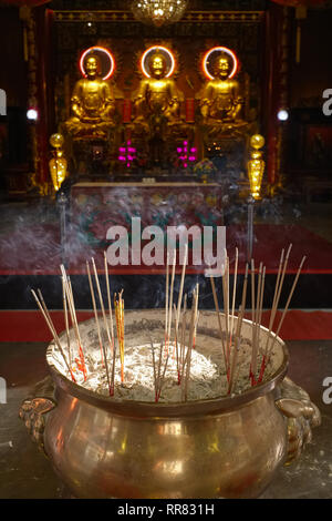 Una nave con la masterizzazione di bastoncini di incenso davanti al santuario principale nel tempio taoista Wat Mangkon Kamalawat, Chinatown, Bangkok, Thailandia Foto Stock