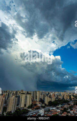 Oscura e drammatica nuvole di pioggia. Aereo in fase di decollo con nuvole temporalesche. Molto heavy rain sky nella città di Sao Paulo, Brasile America del Sud. Foto Stock