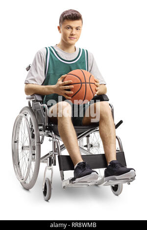 A piena lunghezza Ritratto di un giovane uomo in sedia a rotelle tenendo una palla da basket e sorridente alla telecamera isolata su sfondo bianco Foto Stock