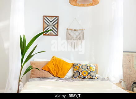 Bianco e beige camera da letto in stile Boho con macrame sulla parete Foto Stock