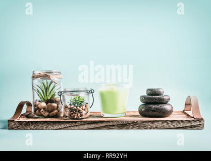 Composizione Spa di candele blu, pietre su sfondo blu Foto stock - Alamy