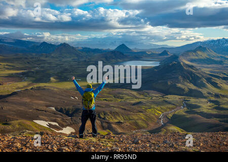 Escursionista guardando sopra le montagne e il lago di Alftavatn, da Jokultungur sul Laugavegur Hiking trail. Highlands Centrali, Sudhurland, Islanda. Foto Stock