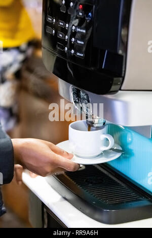 Johannesburg, Sud Africa, 6 Novembre - 2018: macchina da caffè erogazione di caffè nella tazza. Foto Stock