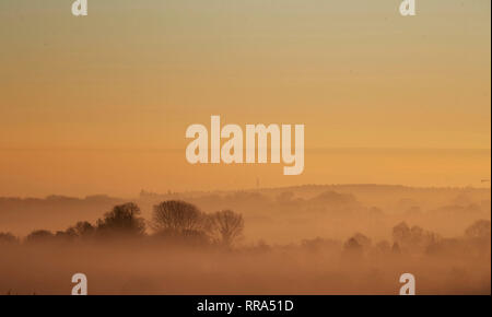 La nebbia sale sopra gli alberi vicino a Guildford nel Surrey. Forecasters hanno detto che dopo questo weekend di unseasonably tempo caldo, temperature più tardi questa settimana dovrebbe tornare normale. Foto Stock