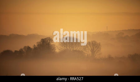 La nebbia sale sopra gli alberi vicino a Guildford nel Surrey. Forecasters hanno detto che dopo questo weekend di unseasonably tempo caldo, temperature più tardi questa settimana dovrebbe tornare normale. Foto Stock