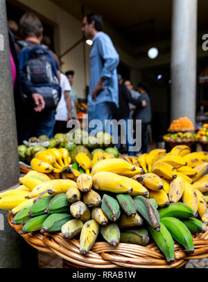 Cestini di banane e altri frutti per la vendita nel mercato Lavradores, Funchal, Madeira, Portogallo. Foto Stock