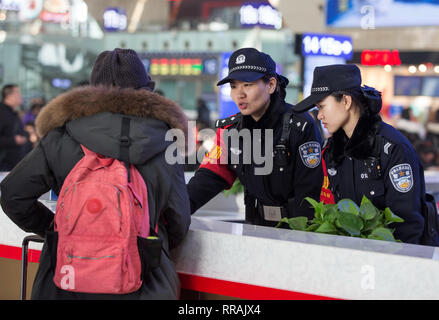 (190225) -- SHIJIAZHUANG, Feb 25, 2019 (Xinhua) -- un passeggero consulta gli ufficiali di polizia Zhang Zi (seconda R) e Wang Lei (1R) a Shijiazhuang stazione ferroviaria del nord della Cina nella provincia di Hebei, nel febbraio 23, 2019. Durante questo anno il Festival di Primavera di viaggio rush, Zhang Zi, un 32-anno-vecchio della polizia ferroviaria, ha lavorato insieme con il suo apprendista Wang Lei, un 24-anno-vecchio officer. Essi sono stati impegnati ad aiutare i passeggeri, la gestione delle emergenze e di mantenere l' ordine in Shijiazhuang stazione ferroviaria. Questa è la coppia del secondo tempo per lavorare insieme durante il Festival di Primavera di viaggio rush. (Xinhua/ Foto Stock