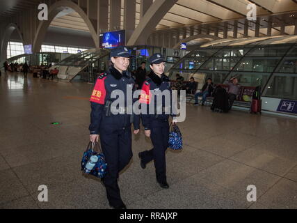 (190225) -- SHIJIAZHUANG, Feb 25, 2019 (Xinhua) -- Zhang Zi (L) e Wang Lei andare alle loro posizioni, a Shijiazhuang stazione ferroviaria nel nord della Cina di nella provincia di Hebei, nel febbraio 23, 2019. Durante questo anno il Festival di Primavera di viaggio rush, Zhang Zi, un 32-anno-vecchio della polizia ferroviaria, ha lavorato insieme con il suo apprendista Wang Lei, un 24-anno-vecchio officer. Essi sono stati impegnati ad aiutare i passeggeri, la gestione delle emergenze e di mantenere l' ordine in Shijiazhuang stazione ferroviaria. Questa è la coppia del secondo tempo per lavorare insieme durante il Festival di Primavera di viaggio rush. (Xinhua/Mu Yu) Foto Stock