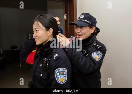 (190225) -- SHIJIAZHUANG, Feb 25, 2019 (Xinhua) -- Zhang Zi (R) consente di Wang Lei con i suoi capelli prima di andare al lavoro in Shijiazhuang, a nord della Cina di nella provincia di Hebei, nel febbraio 23, 2019. Durante questo anno il Festival di Primavera di viaggio rush, Zhang Zi, un 32-anno-vecchio della polizia ferroviaria, ha lavorato insieme con il suo apprendista Wang Lei, un 24-anno-vecchio officer. Essi sono stati impegnati ad aiutare i passeggeri, la gestione delle emergenze e di mantenere l' ordine in Shijiazhuang stazione ferroviaria. Questa è la coppia del secondo tempo per lavorare insieme durante il Festival di Primavera di viaggio rush. (Xinhua/Mu Yu) Foto Stock