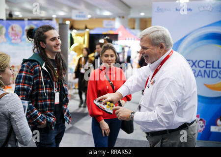 (190225) -- NEW YORK, Feb 25, 2019 (Xinhua) -- Ken Silvestri (1R), un lavoratore dello staff di Choo Choo scarpe, mostra i prodotti della società per i visitatori al loro stand durante la 116annuale di North American International Toy Fair a Jacob K. Javits Convention Center di New York, gli Stati Uniti, nel febbraio 18, 2019. Più imponente delle tariffe per la Cina avrebbe paralizzano il business del piccolo giocattolo negli Stati Uniti le aziende che hanno fatto molte storie di successo con i partner cinesi durante gli ultimi decenni, un'industria insider ha avvertito. 'Penso che avrebbe messo noi fuori del business. Avrebbe messo la maggior parte dei compani Foto Stock