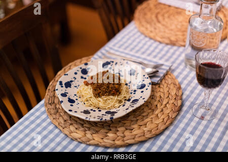Spaghetti alla bolognese servita con il vino Foto Stock