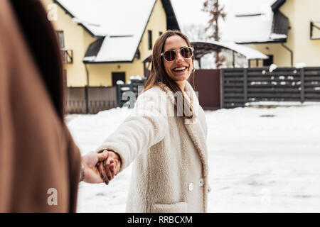 Moglie con buon umore tenendo la mano del suo forte uomo di sostegno Foto Stock