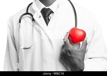 Indian medic uomo con cuore in plastica rosso vicino al torace come cardiologo concetto in bianco e nero di close-up Foto Stock