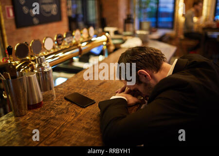 Imprenditore ubriaco in bar Foto Stock