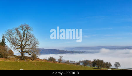 Una drammatica inversione di cloud si svolge nel Parco Nazionale di Brecon Beacons su un luminoso mattino senza nuvole in febbraio, Wales, Regno Unito Foto Stock