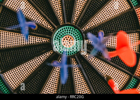 Centro di un bullseye con colorati freccette inchiodato, obiettivo concetto. Foto Stock
