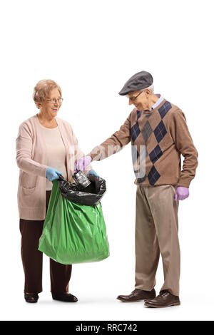 A piena lunghezza shot di un anziano uomo e donna mettendo un rifiuto può in un in un sacco dei rifiuti di plastica isolati su sfondo bianco Foto Stock