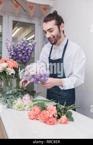 Small business. Fioraio maschio nel negozio di fiori. Floral design studio, rendendo le decorazioni e le modalità. Consegna di fiori a domicilio, creare l'ordine. L'uomo nelle femmine di professione. La parità tra i sessi concept Foto Stock