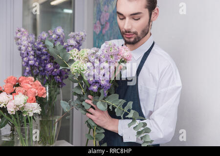 Small business. Fioraio maschio nel negozio di fiori. Floral design studio, rendendo le decorazioni e le modalità. Consegna di fiori a domicilio, creare l'ordine. L'uomo nelle femmine di professione. La parità tra i sessi concept Foto Stock