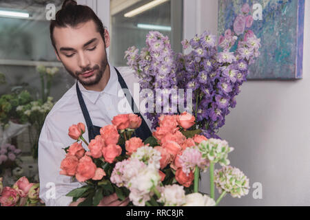 Small business. Fioraio maschio nel negozio di fiori. Floral design studio, rendendo le decorazioni e le modalità. Consegna di fiori a domicilio, creare l'ordine. L'uomo nelle femmine di professione. La parità tra i sessi concept Foto Stock