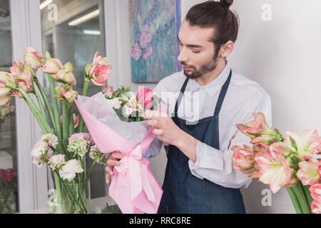 Small business. Fioraio maschio nel negozio di fiori. Floral design studio, rendendo le decorazioni e le modalità. Consegna di fiori a domicilio, creare l'ordine. L'uomo nelle femmine di professione. La parità tra i sessi concept Foto Stock