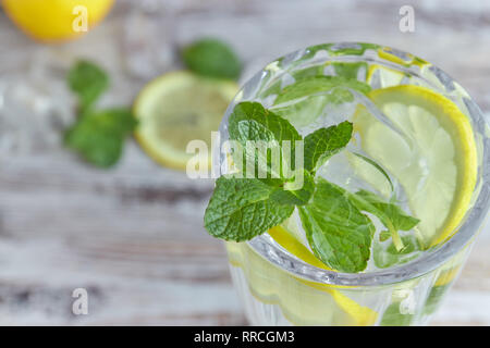 Un bicchiere di acqua fresca con ghiaccio, limone e menta. Messa a fuoco selettiva. dissetante bevanda estiva. grande. Foto Stock