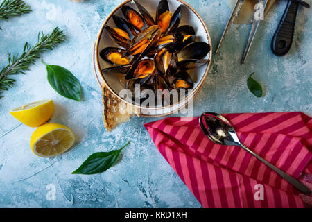 Le cozze nella piastra servita con pomodori, toast e limone Foto Stock