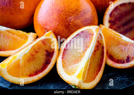 Fresche succose arance di sangue intero e affettato Close Up (macro) profondità di campo Foto Stock