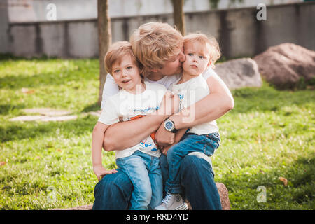 Padre Felice con due piccoli figli in posizione di parcheggio Foto Stock