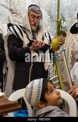 Gerusalemme - 23 settembre: un uomo non identificato e ragazzo prendere parte a un servizio di preghiera presso il Muro Occidentale, ebraismo il santissimo sito, durante il Sukkot hol Foto Stock