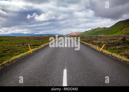 Stretto strada asfaltata attraverso il campo di lava nel Nordest dell'Islanda, in Scandinavia - nordic concetto di viaggio Foto Stock