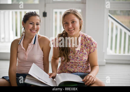 Ragazze libro lettura insieme sul portico Foto Stock