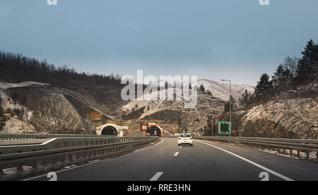 Scena invernale, vista da auto, guida su autostrada nella parte anteriore del tunnel. Foto Stock