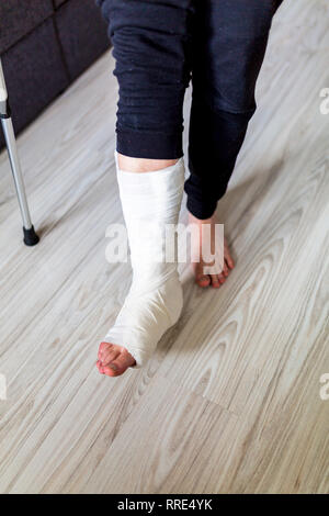 Camminare sulle stampelle con una gamba in un cast Foto Stock