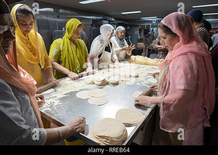 Donne volontari per un langar, un tempio sikh cucina, preparare roti, una rotonda pane sottile. In South Richmond Hill, Queens, a New York City. Foto Stock