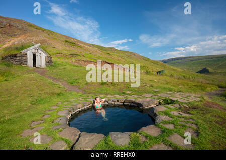 Donna di balneazione in Gudrunarlaug piscina geotermica. Laugar, Saelingsdalur, west Islanda. Foto Stock