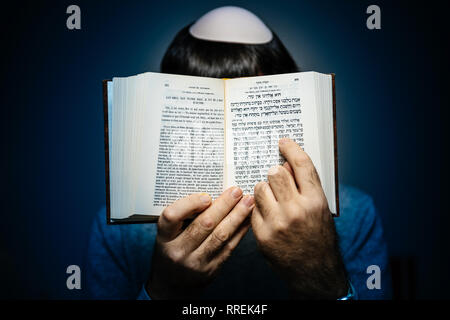Maschio ebreo indossando kippa , lettura orante bi-lingue ebraico mahzor francese libro di preghiera da 1920 utilizzato in alto i Giorni santi di Rosh Hashanah e Yom Kippur - bollino blu. Foto Stock