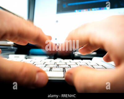 Maschio di lavoro le mani sulla tastiera del computer la scrittura di riproduzione utilizzando i moderni computer con cappucci bianchi e cirillico e i caratteri della lingua inglese - veloce digitando la riproduzione premendo Foto Stock