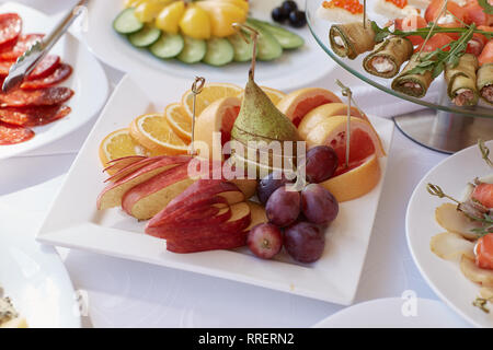 Le uve, arancione e pere da tavola Foto Stock