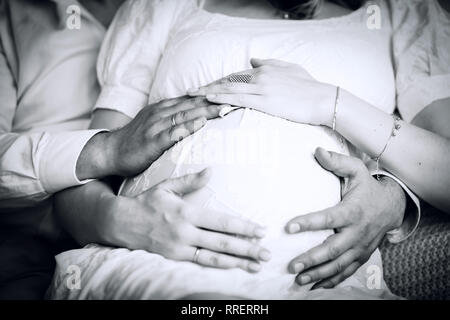 La foto in stile retrò. marito abbracciando il ventre di sua moglie incinta Foto Stock